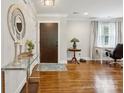Inviting foyer with hardwood floors, decorative mirror, glass table, and a modern front door at 7200 Monroe Rd, Charlotte, NC 28212