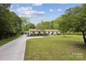 Well-manicured lawn and long driveway leading to a charming single-story home at 7200 Monroe Rd, Charlotte, NC 28212
