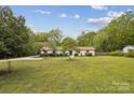 Expansive front yard showcases this single-story home with mature trees and a basketball hoop at 7200 Monroe Rd, Charlotte, NC 28212