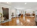 Spacious living area with hardwood floors, a modern front door, and an open layout to the dining area at 7200 Monroe Rd, Charlotte, NC 28212