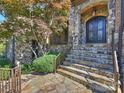 Charming stone archway and iron double doors create an inviting entrance, accented by professional landscaping at 7311 Barrington Ridge Dr, Fort Mill, SC 29707