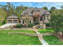 Beautiful brick home with an attached garage, lush landscaping, and a stone walkway leading to the front door at 7311 Barrington Ridge Dr, Fort Mill, SC 29707