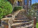 Elegant stone stairway with metal railings leading to the home's entrance, enhanced by lush greenery at 7311 Barrington Ridge Dr, Fort Mill, SC 29707
