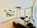 Inviting living room featuring hardwood floors, a comfortable sectional, and ample natural light from large windows at 9007 Mcmillian Dr, Harrisburg, NC 28075