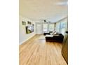 Bright living room with hardwood floors, a ceiling fan, and a comfortable sectional sofa by the windows at 9007 Mcmillian Dr, Harrisburg, NC 28075