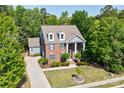 Expansive aerial view of a brick home surrounded by mature trees, and a long driveway with an attached garage at 9810 Daufuskie Dr, Charlotte, NC 28278