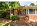 Traditional brick home with a cozy front porch and well-kept landscaping at 10316 Whitethorn Dr, Charlotte, NC 28277