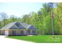 Expansive brick home with gray roofing and shutters, a green lawn, and a flagpole displaying the American flag at 107 Garden Ter, Dallas, NC 28034