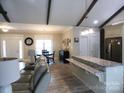 Open-concept living area with wood-look flooring, granite countertops, and exposed beams at 107 Garden Ter, Dallas, NC 28034