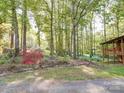 Landscaped yard with mature trees and flowering shrubs create a peaceful and private wooded home setting at 110 Dutch Creek Rd, Rockwell, NC 28138