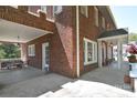 Spacious brick home with a covered porch, featuring a seating area and a well-manicured lawn at 122 Corban Se Ave, Concord, NC 28025