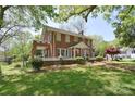 Beautiful brick home featuring a classic design, lush landscaping, and a welcoming front porch at 122 Corban Se Ave, Concord, NC 28025