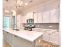 Well-lit kitchen with white cabinets, stainless appliances, and a tile backsplash at 13063 Arnold Palmer Cir # 839, Lancaster, SC 29720