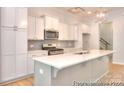 Modern kitchen with white cabinets, stainless steel appliances, and a large center island at 13063 Arnold Palmer Cir # 839, Lancaster, SC 29720