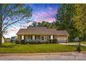 Inviting single-story home with a well-manicured lawn, charming front porch and attached garage with driveway at 140 Hazelwood Dr, Rockwell, NC 28138