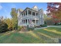 Charming two-story home boasts double porches and stone accents, set on a beautifully landscaped lot at 14010 Promenade Dr, Huntersville, NC 28078