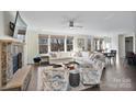 Spacious living room featuring a stone fireplace, large windows, and comfortable seating at 14010 Promenade Dr, Huntersville, NC 28078