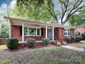 Charming brick home with a well-maintained lawn, blue door and inviting curb appeal at 1408 Wicker Dr, Charlotte, NC 28210