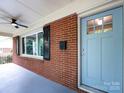 The front porch features a blue door, black mail box, and a ceiling fan at 1408 Wicker Dr, Charlotte, NC 28210