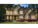 Inviting exterior view of the home, featuring stonework and warm lighting at 14130 Lea Point Ct, Huntersville, NC 28078