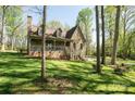 Charming stone-accented home with a cozy front porch surrounded by lush greenery at 1524 Court Cir, Newton, NC 28658