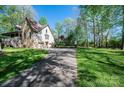 Spacious home with a long driveway leading to an attached garage, surrounded by mature trees at 1524 Court Cir, Newton, NC 28658