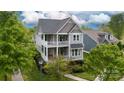 An aerial view of a charming two-story home with double porches nestled amongst lush greenery at 19034 Cypress Garden Dr, Davidson, NC 28036
