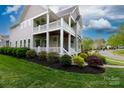 Inviting home exterior featuring a double porch, lush landscaping, and manicured lawn at 19034 Cypress Garden Dr, Davidson, NC 28036