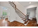 Elegant staircase with dark wood and wrought iron banister, leading to the upper level of the home at 208 Grasshopper Cir, Mooresville, NC 28117