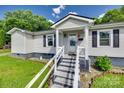 Close-up of the home's inviting front porch, featuring stairs, weathered rails, and stylish design elements at 220 Tomberlin Rd, Mount Holly, NC 28120