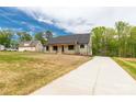 Craftsman-style home with wood columns, green siding, and a long concrete driveway at 2212 University Dr, Lancaster, SC 29720