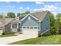 Charming blue home featuring a two-car garage, well-manicured lawn, and inviting curb appeal at 24558 Blue Heron Cir # 402, Lancaster, SC 29720
