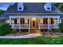 Close-up of a charming covered front porch with white railings and a brick facade at 308 Valhalla Dr, Harrisburg, NC 28075