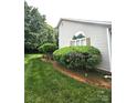 Charming exterior detail with a manicured shrubbery and a lovely, bright window at 317 Robert Keever Rd, Stanley, NC 28164