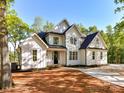 Charming two-story home features a classic white facade, complemented by lush landscaping and a spacious driveway at 3308 Watkins Rd, Monroe, NC 28110