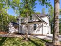 Side view of a gorgeous two-story home with lush landscaping and a large driveway leading to a multi-car garage at 3308 Watkins Rd, Monroe, NC 28110