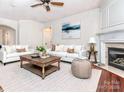 Bright living room with a fireplace and hardwood floors is filled with natural light and furnished with comfortable seating at 43014 Mimosa Ct, Indian Land, SC 29707