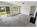 Cozy living room featuring a fireplace and sliding glass doors to the backyard at 4437 Devonhill Ln, Charlotte, NC 28269