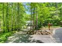 View of secluded home from a long driveway, surrounded by lush trees and landscaping at 4516 Stryker Dr, Matthews, NC 28104
