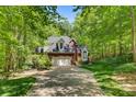 Brick home with a two car garage and a long driveway surrounded by trees and lawn at 4516 Stryker Dr, Matthews, NC 28104