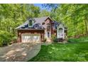 Charming brick home with a two-car garage, manicured lawn and verdant surrounding trees at 4516 Stryker Dr, Matthews, NC 28104
