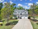 Beautiful two-story home showcasing a long driveway, lush landscaping, and an inviting front porch at 5025 Willing Ct, Fort Mill, SC 29707