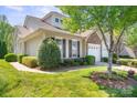 Charming home featuring a two car garage, a stone facade, and beautiful landscaping and manicured lawn at 512 Park View Dr, Belmont, NC 28012