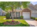 Charming home featuring a one car garage, a stone facade, and beautiful landscaping and manicured lawn at 512 Park View Dr, Belmont, NC 28012