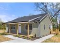 Charming home showing the covered front porch and an adjacent small deck, surrounded by a green lawn at 6525 Kershaw Camden Hwy, Heath Springs, SC 29058