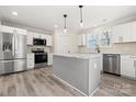 Modern kitchen featuring white cabinets, stainless steel appliances, a center island and light wood-look floors at 6525 Kershaw Camden Hwy, Heath Springs, SC 29058