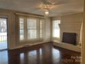 Bright living room with hardwood floors, a brick fireplace, and large windows for natural light at 8350 Nc Hwy 90 E Hwy, Stony Point, NC 28678