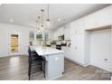 Bright kitchen with white cabinets, quartz countertops, and a large center island with bar stool seating at 9913 Jack Nicklaus Dr # 908, Lancaster, SC 29720