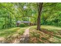 View of a brick home surrounded by mature trees and greenery, showcasing the property's peaceful setting at 102 Forest Ct, Huntersville, NC 28078