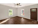 Spacious bedroom with two windows, a ceiling fan, and a dark wood-look floor at 119 Washington St, York, SC 29745